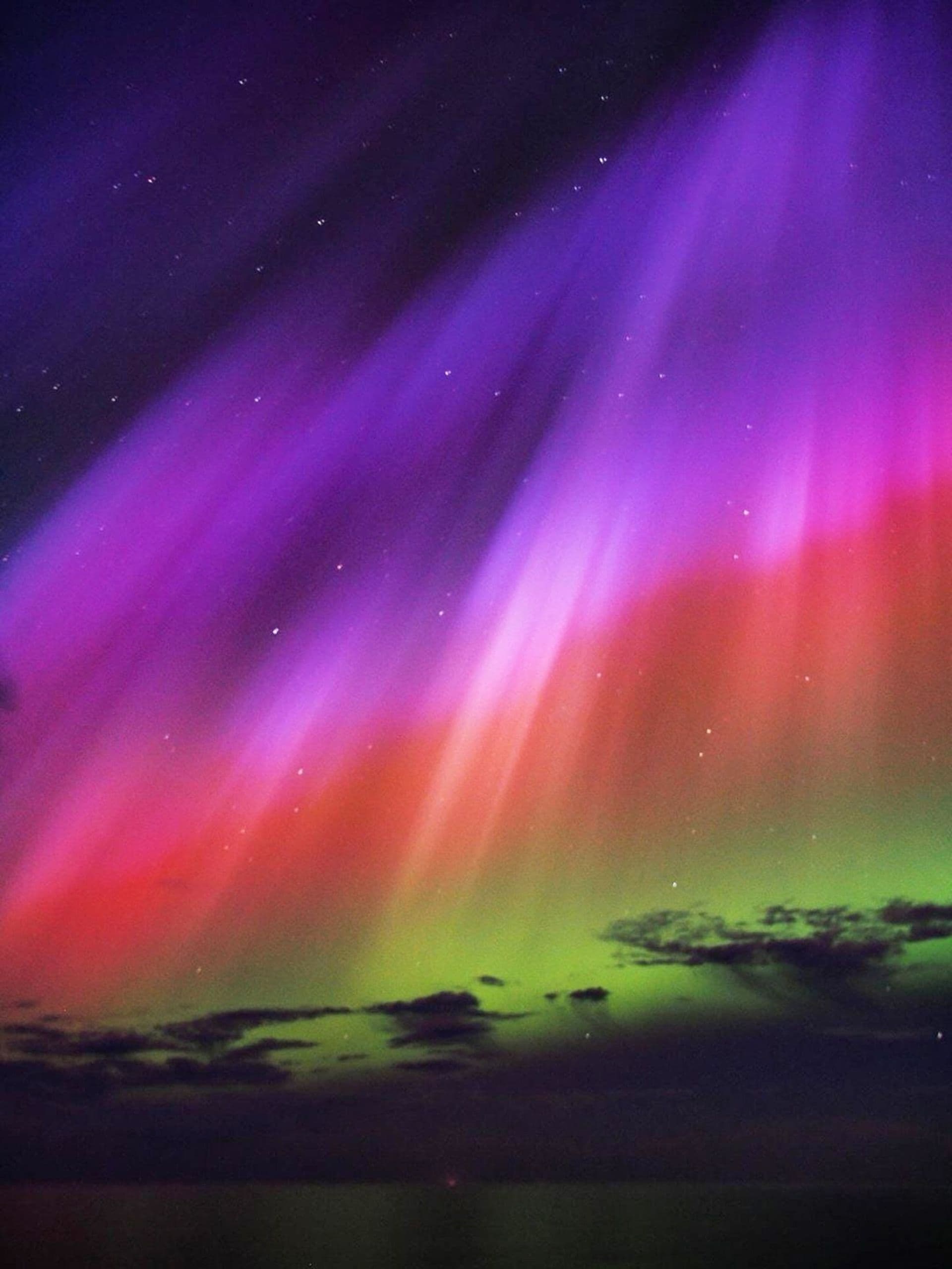 Bright northern lights over a dark landscape